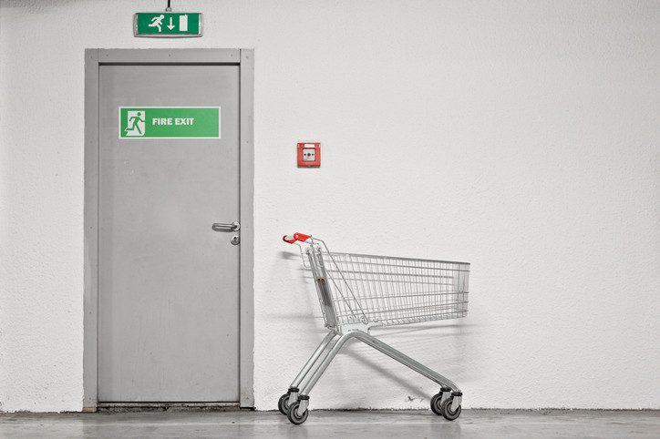 Photo of shopping cart next to fire exit door.