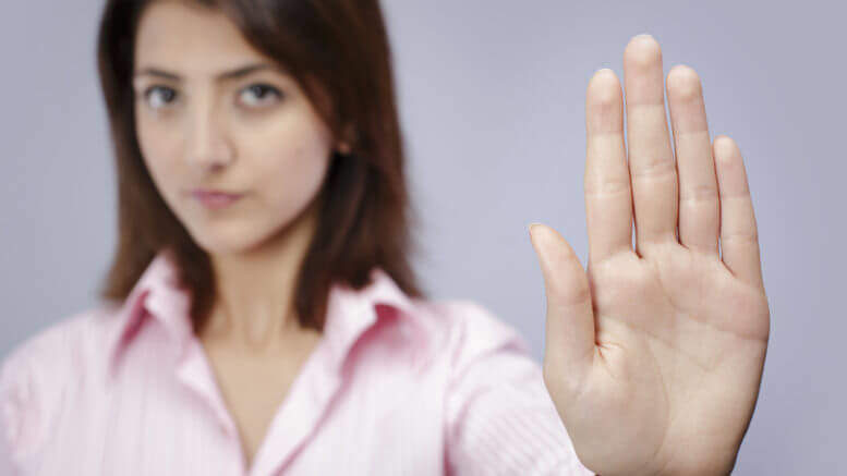 Woman putting her hand up to say stop.