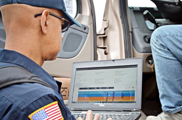 A truck driver records his hours on an electronic logging device