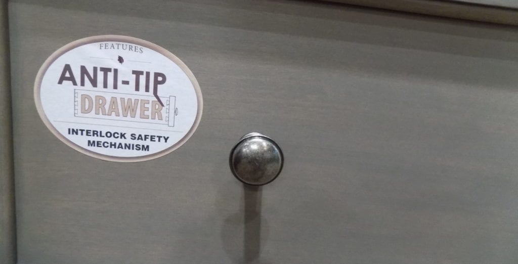 Image shows a safety sticker on a dresser drawer