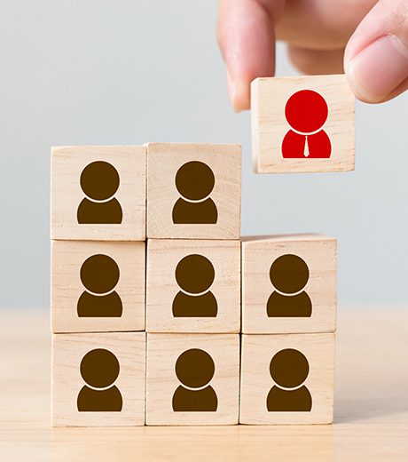 a hand building a stack of blocks with people on the front.