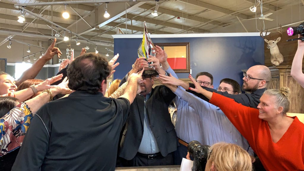 Employees reaching for the HFA Retailer of the Year Award