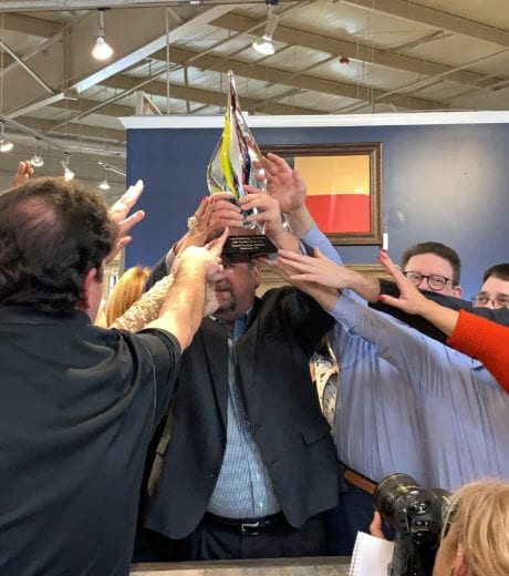 Employees reaching for the HFA Retailer of the Year Award
