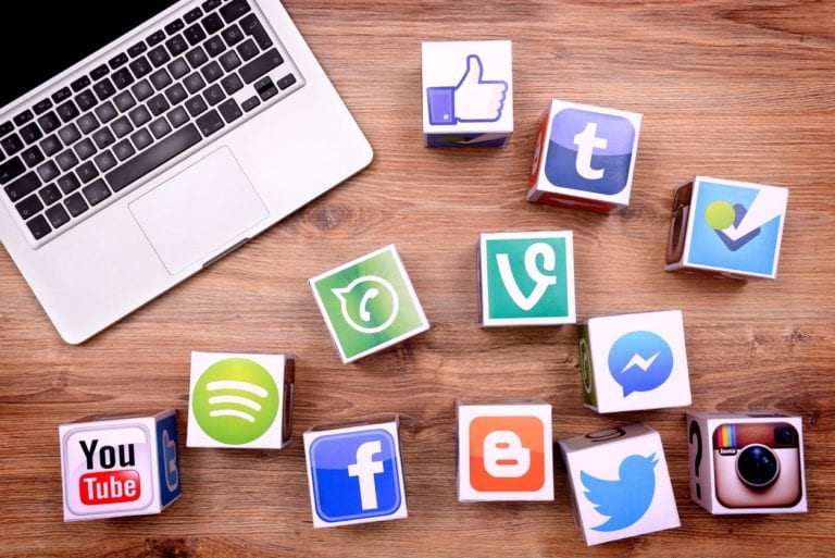 A computer and social media logos on desk