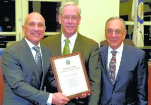 Image shows three men during an award presentation