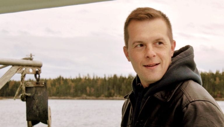 Image shows a young man wearing a hooded sweatshirt