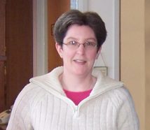 Image shows a woman with glasses and wearing a sweater