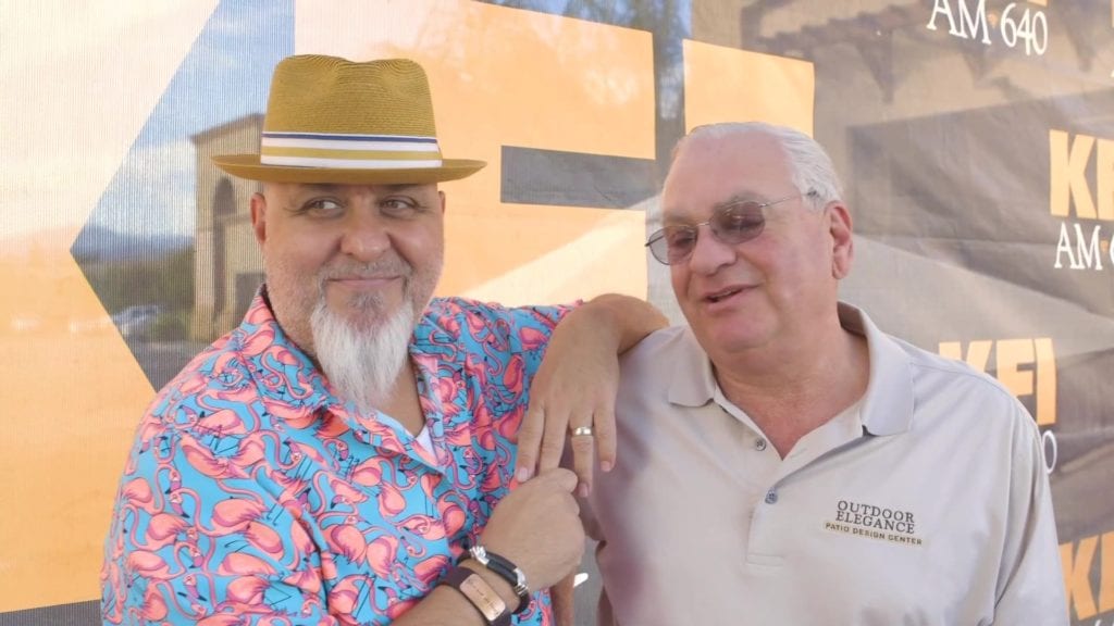 Image shows two men, one wearing a hat