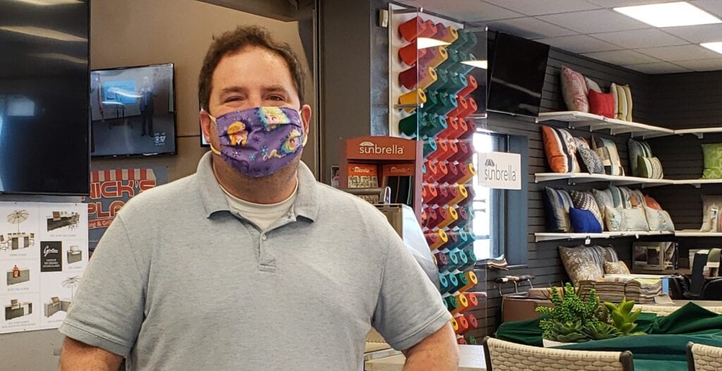 Image shows a man wearing a face covering