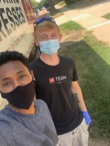 Image shows two young men wearing face coverings