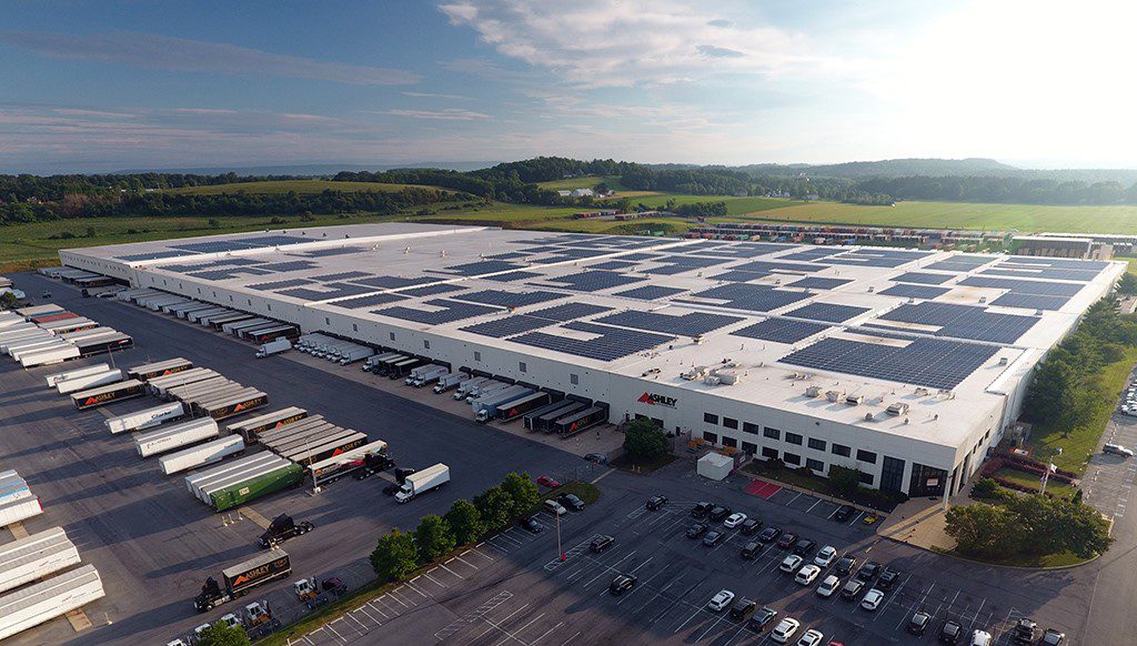 Image shows an industrial facility with solar panels on its roof