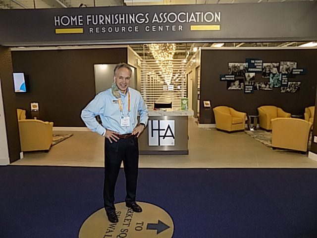 Image shows a man standing in front of a furniture showroom