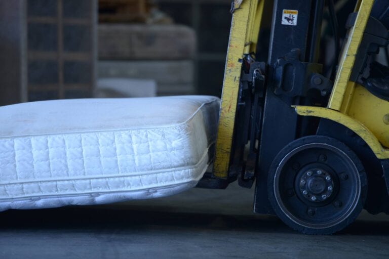 Image shows a forklift carrying a mattress