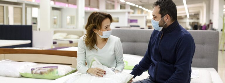 Couple in a mattress store wearing face masks