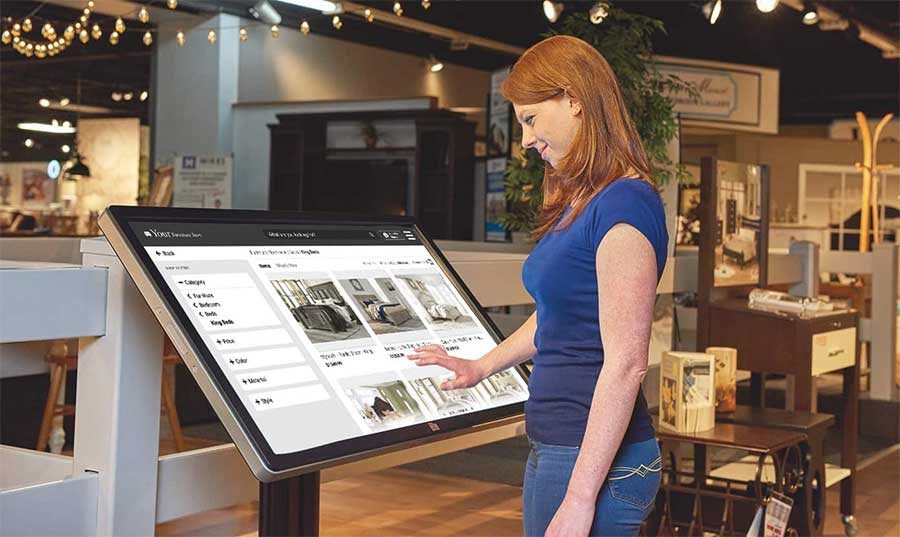 Shopper using an endless isle kiosk in a furniture store