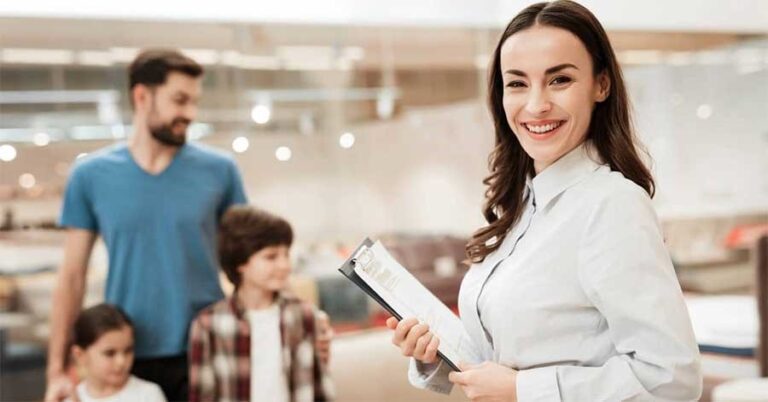 Salesperson with clipboard helping a family shop.