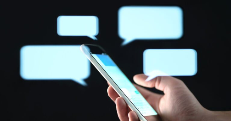 Text messages in cellphone screen with abstract hologram speech bubbles.