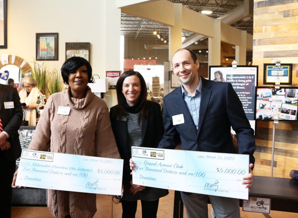 Randi Komisar presenting big checks to two people