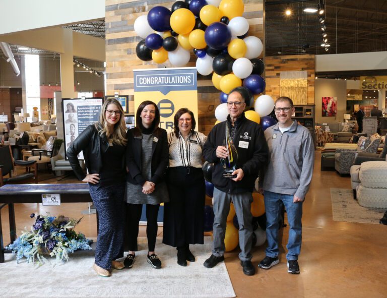 Biltrite Family with HFA 2023 Retailer of the Year Award, standing in furniture showroom