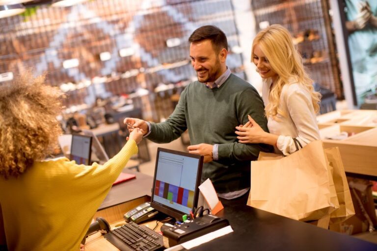 Young couple paying the cashier for a furniture purchase.