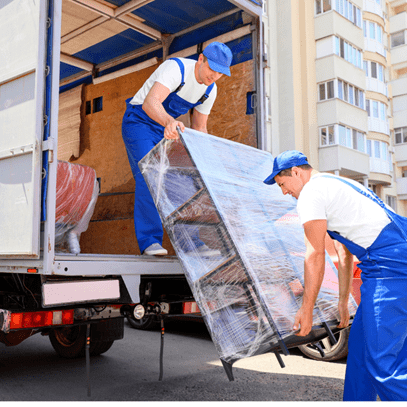 Two men in blue overalls unloading a curio from a delivery truck