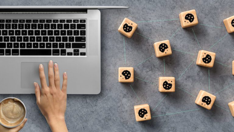 laptop computer on desk with dice featuring cookie pictures along the side.