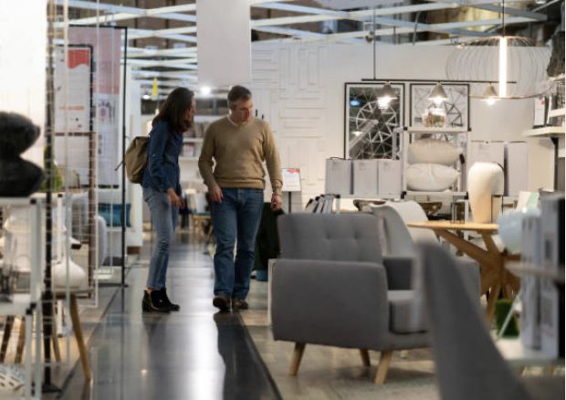 man and a woman looking at furniture in a furniture store.