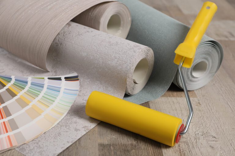 home improvement with a paint roller, wallpaper rolls and color samples