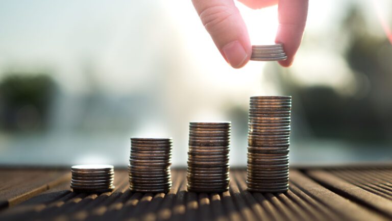 Hand putting money coins stack growing, saving money for purpose concept