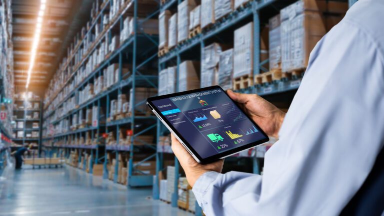 Smart Warehouse,Inventory management system concept.Manager using digital tablet,showing warehouse software management dashboard on blurred warehouse as background