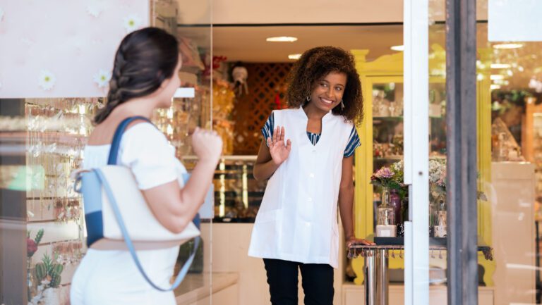 Owner greets customer in front of store