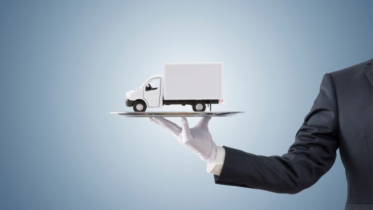 Businessman offering cargo delivery truck on silver tray