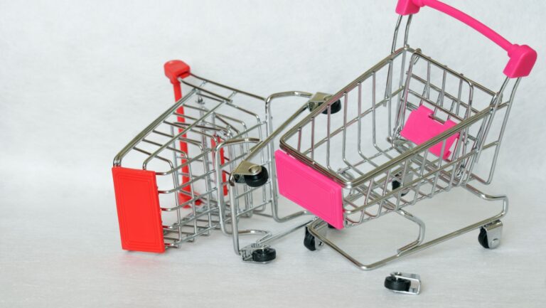 Two broken supermarket trolleys with a falling wheel on a white background. eCommerce cart abandoment.