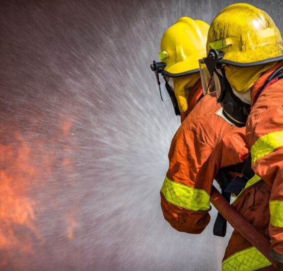 2 firefighters spraying high pressure water to fire