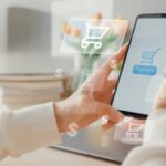 female hands holding a phone and online shopping in a home.