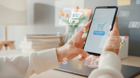female hands holding a phone and online shopping in a home.