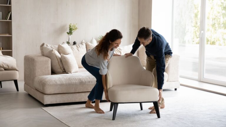Couple positioning furniture in their home