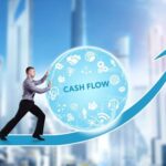 Graphic depicting a man rolling a ball that says Cash Flow up an arrow.