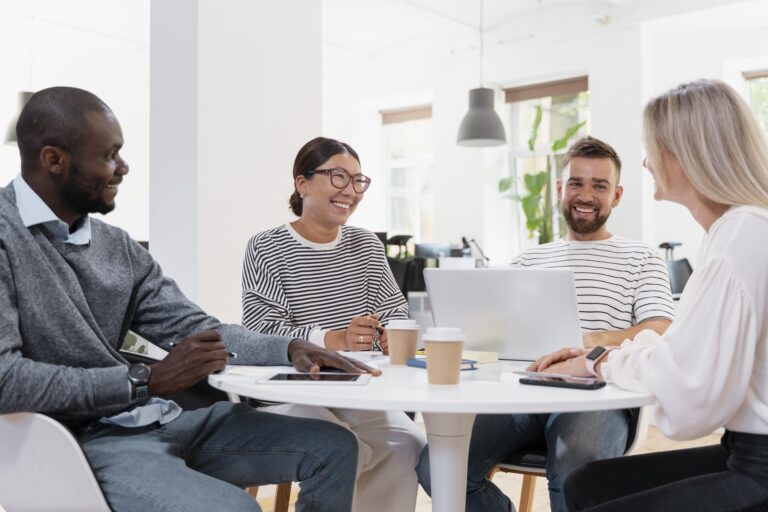 colleagues having a meeting sitting at a white table.