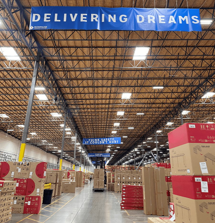 A furniture warehouse with boxed inventory. Sign showing how important safety is.