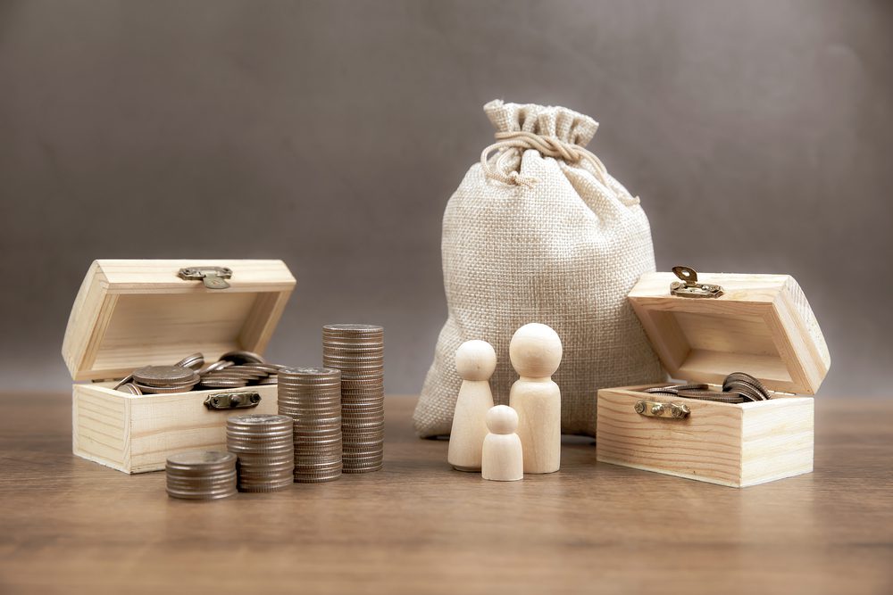 Many coins are stacked in a graph shape with family icons for money saving ideas and financial planning insurance.