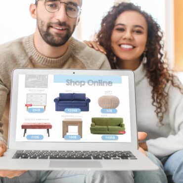 Young couple with laptop buying online new furniture at home
