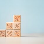 interest, rates, compare, savings, deposit, Stacked wooden blocks with percentage symbols and arrows pointing upward, representing rising interest rates, finance, inflation, and investment growth.