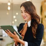 Smile, business woman and tablet in hotel for online booking, reservation schedule or information update. Digital technology, worker and internet communication with hospitality manager on checkin app