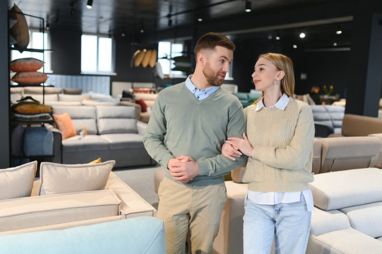 Couple choosing sofa and pillows at furniture store.