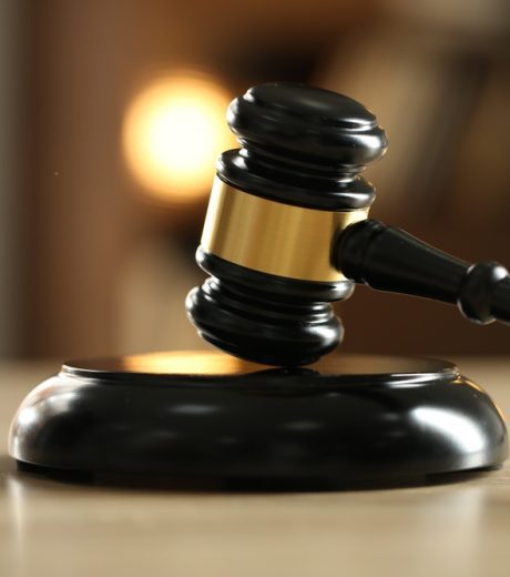 Judge's gavel on wooden table against blurred background, closeup
