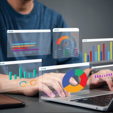 Business analyst working on laptop with holographic dashboard charts and data visualization graphs. Concept of big data, analytics, business intelligence, and financial statistics. crm marketing