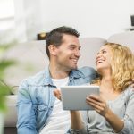 Relaxed young couple using a tablet in their living room