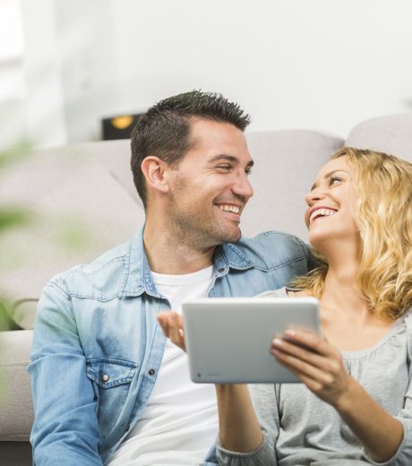 Relaxed young couple using a tablet in their living room