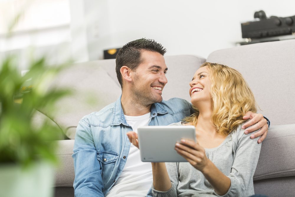 Relaxed young couple using a tablet in their living room